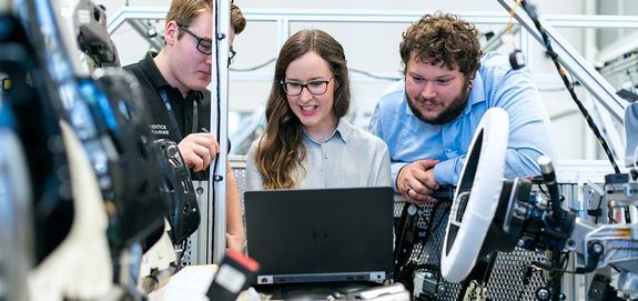 Foto: Team von Maschinenbauern an einem gemeinsamen Projekt